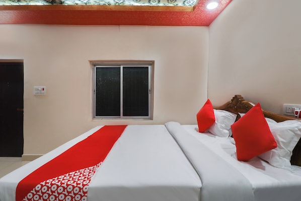 Una habitación de hotel con cama, ventana y puerta.