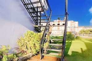 A staircase leading to a balcony with a view of a building and a grassy area. - Hotel O Govind Guest house (Dehradun)