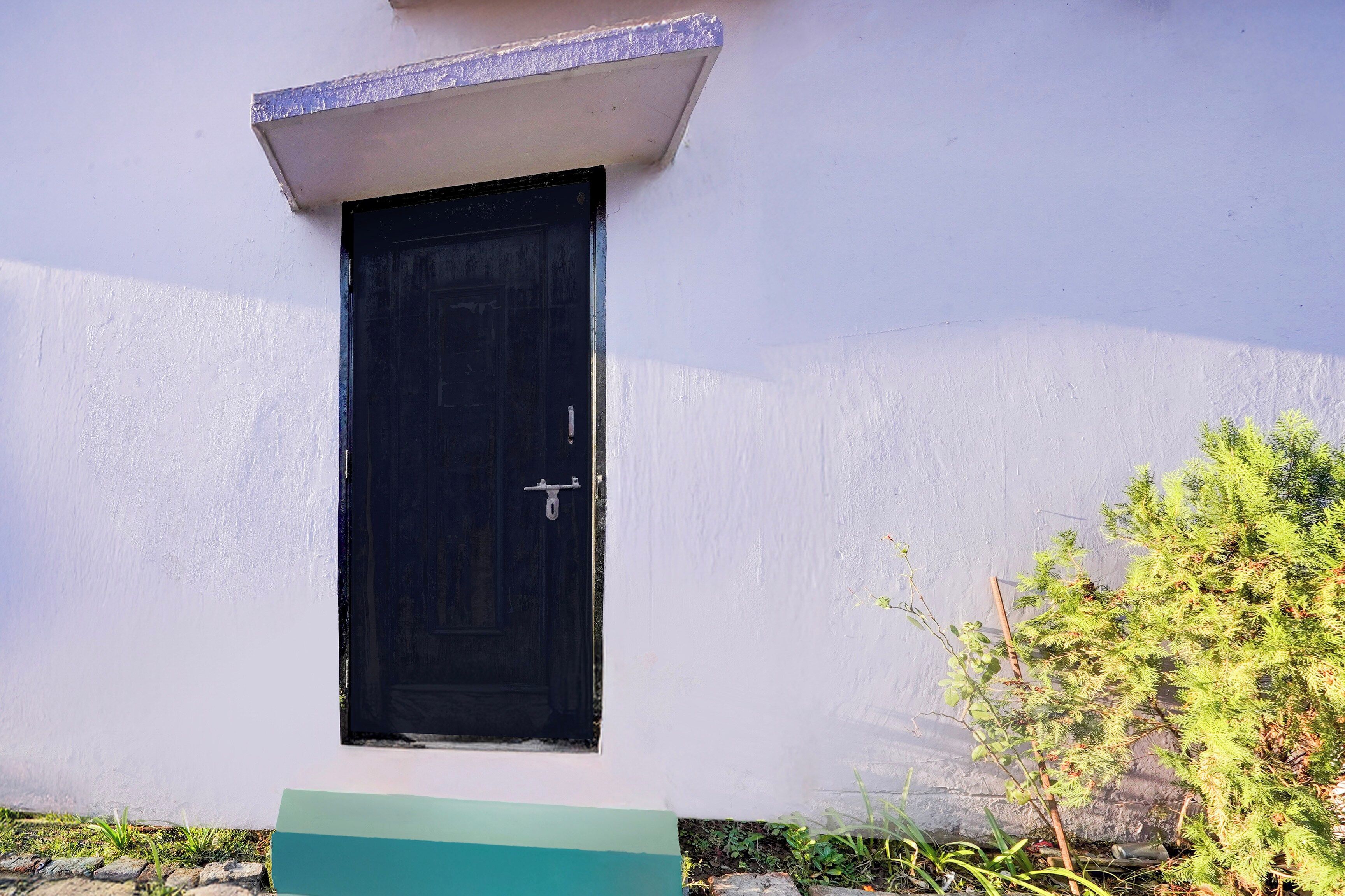 A black door with a metal handle, a small window above it, and a white wall.