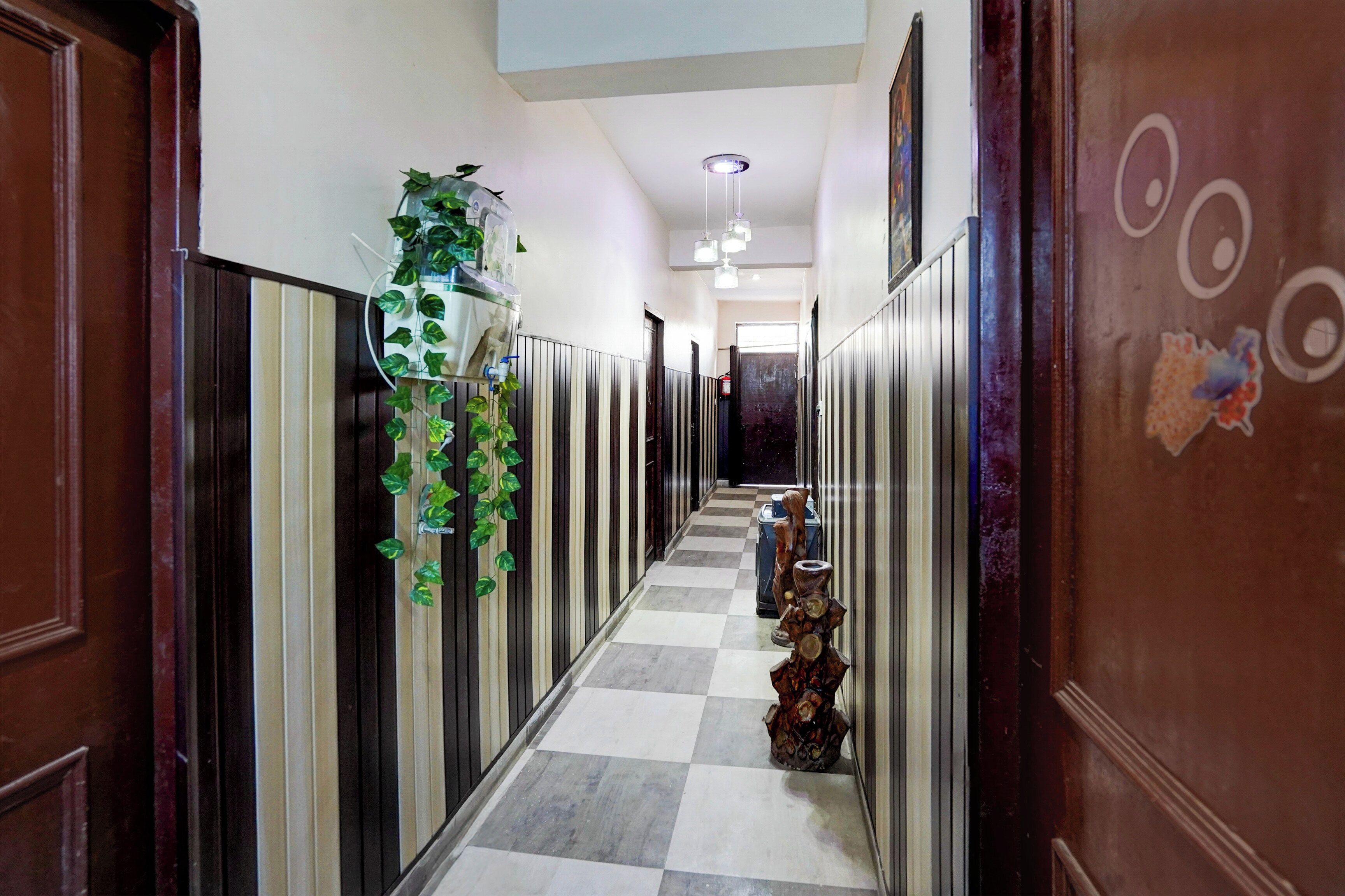 A hallway with a checkered floor, wooden doors, and a wall-mounted water dispenser.
