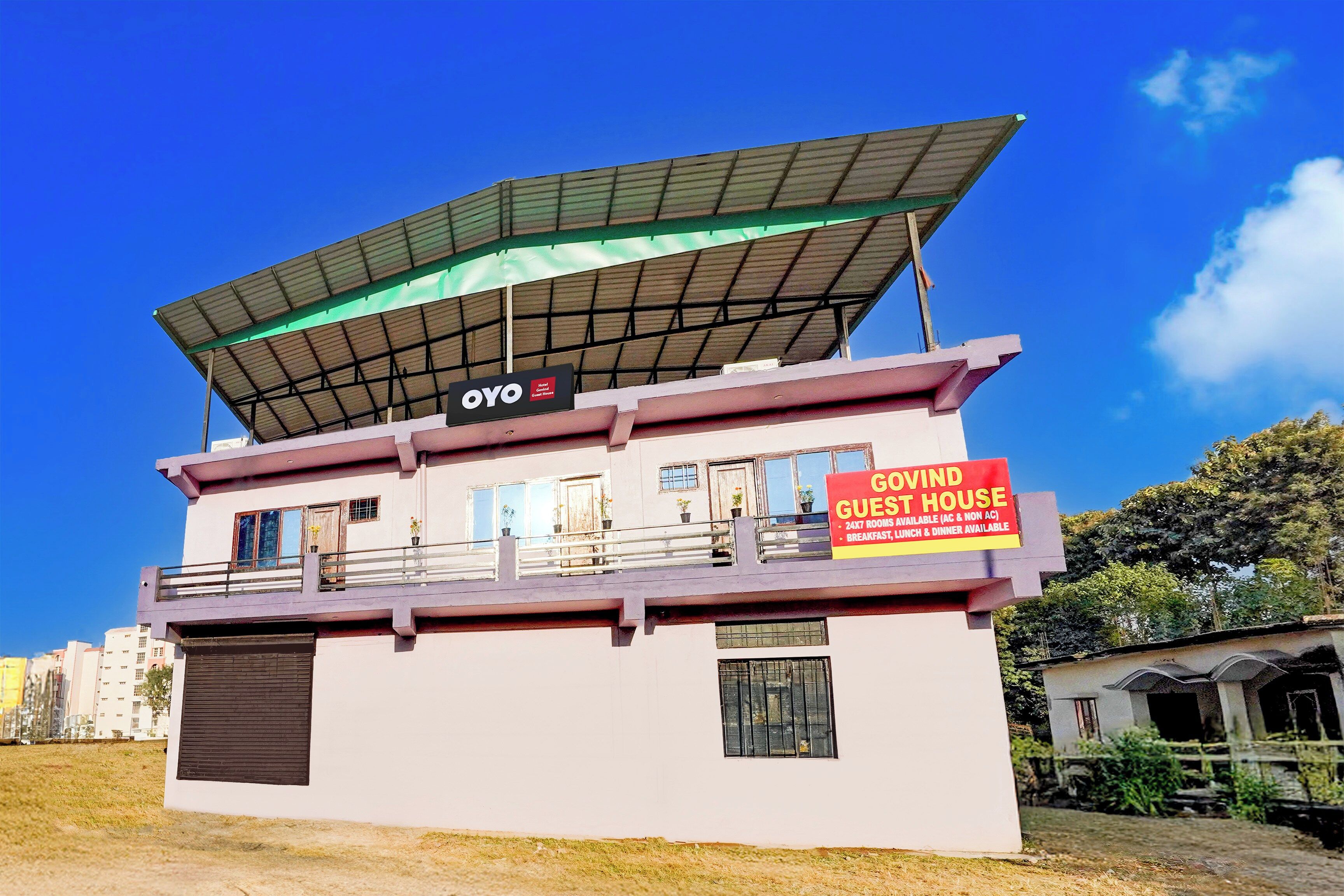 A two-story building with a sign indicating it is a guest house.