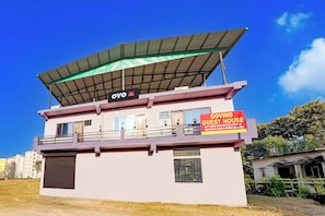 A two-story building with a sign indicating it is a guest house. - Hotel O Govind Guest house (Dehradun)