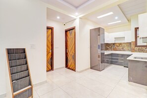 Una cuina moderna amb salabost d'unió de marbre, illa integrada i vista cap a la zona de dia adjacent.