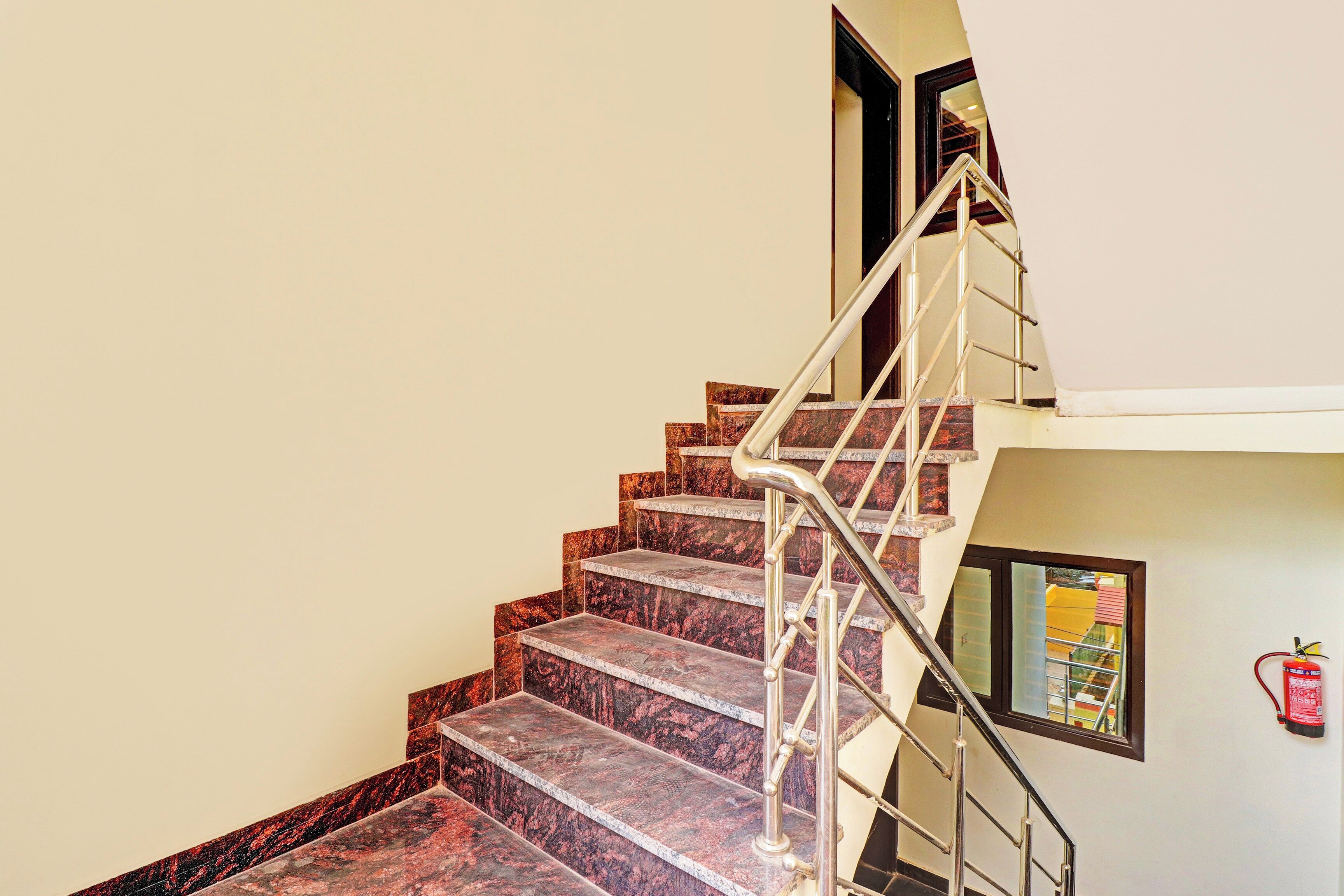 A staircase with marble steps and a metal handrail leading to an upper floor.