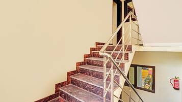 A staircase with marble steps and a metal handrail leading to an upper floor.