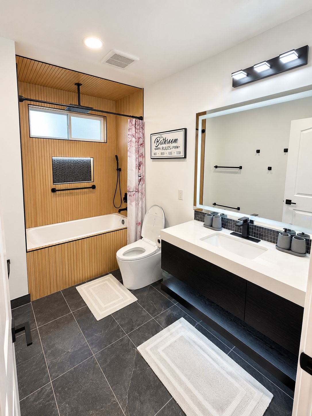 Une salle de bain moderne avec des toilettes, un lavabo et un miroir.
