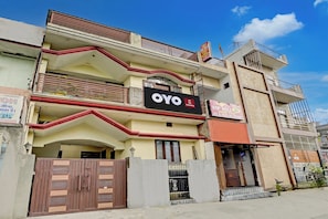A multi-story building with a prominent black sign for OYO hotel. - HOTEL O VIP HILL HOMESTAY (Dehradun)