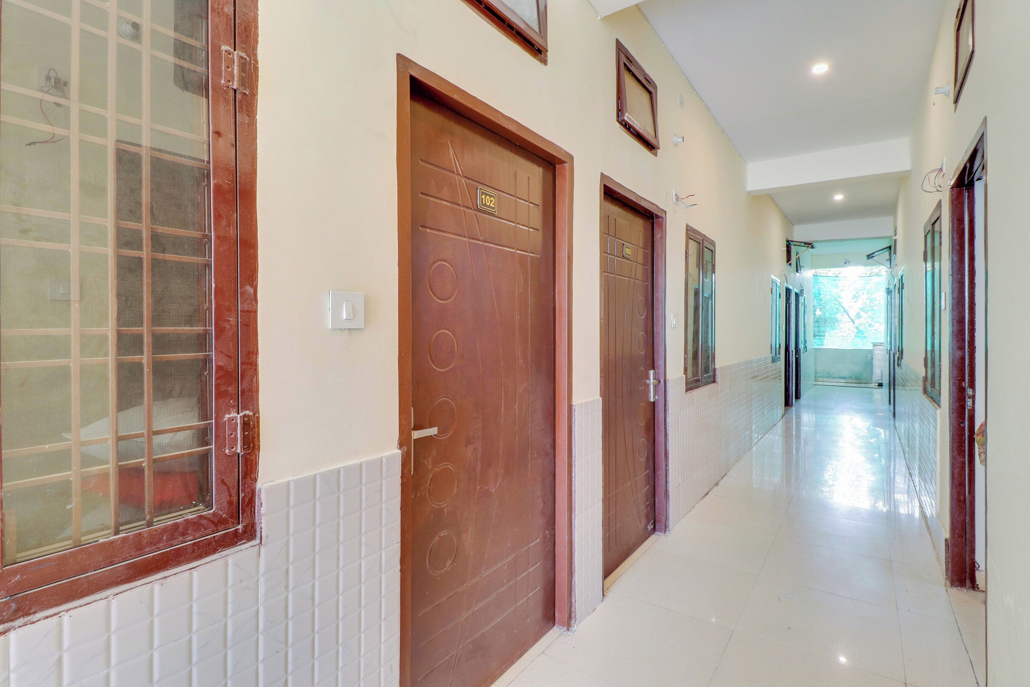 A corridor with doors, a tiled wall, and a window.
