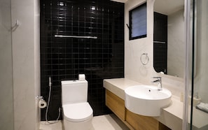 Un bagno moderno con toilette, lavandino e specchio.