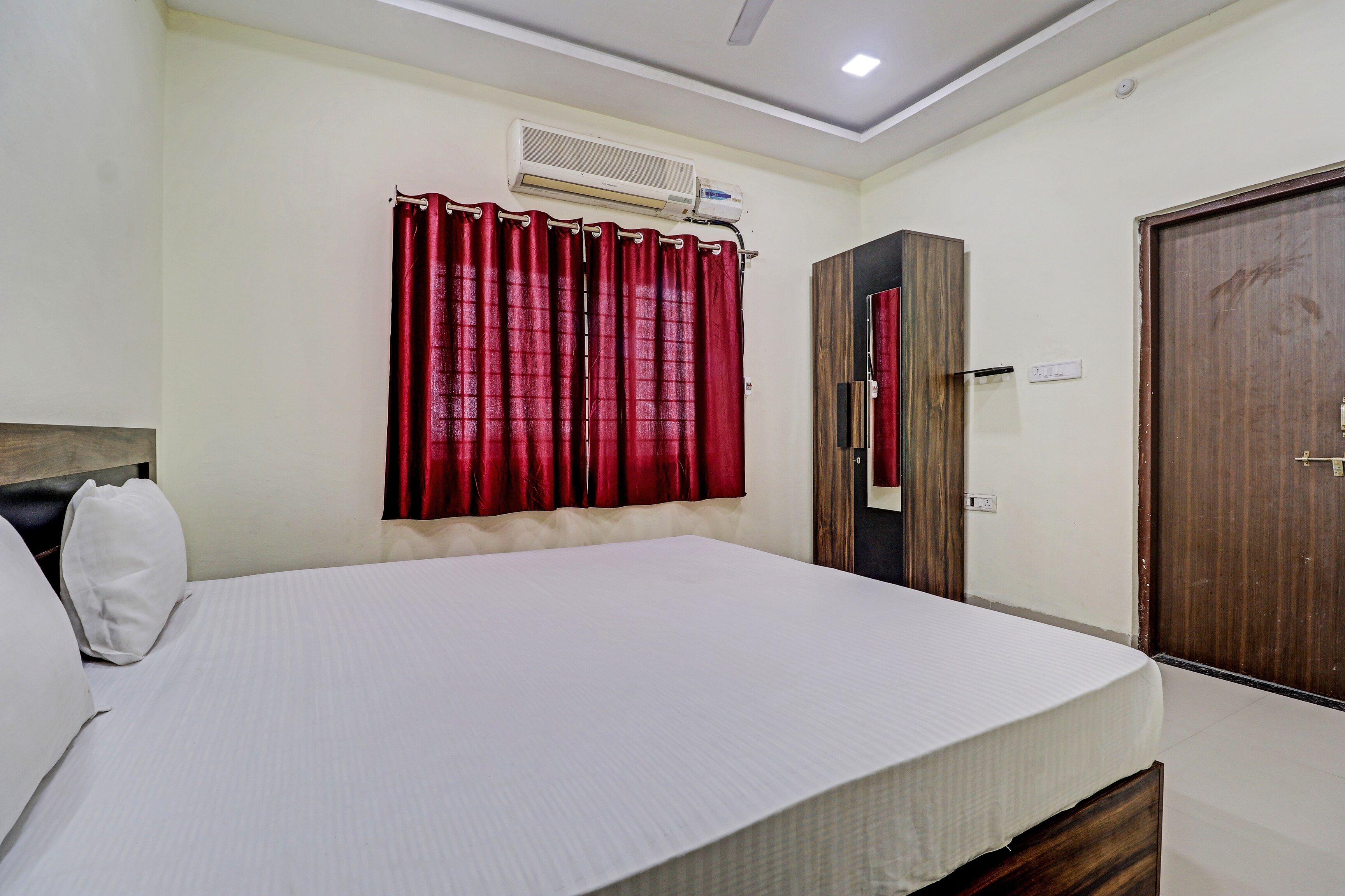 A bedroom with a bed, a wardrobe, and a door.