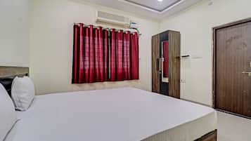 A bedroom with a bed, a wardrobe, and a door.