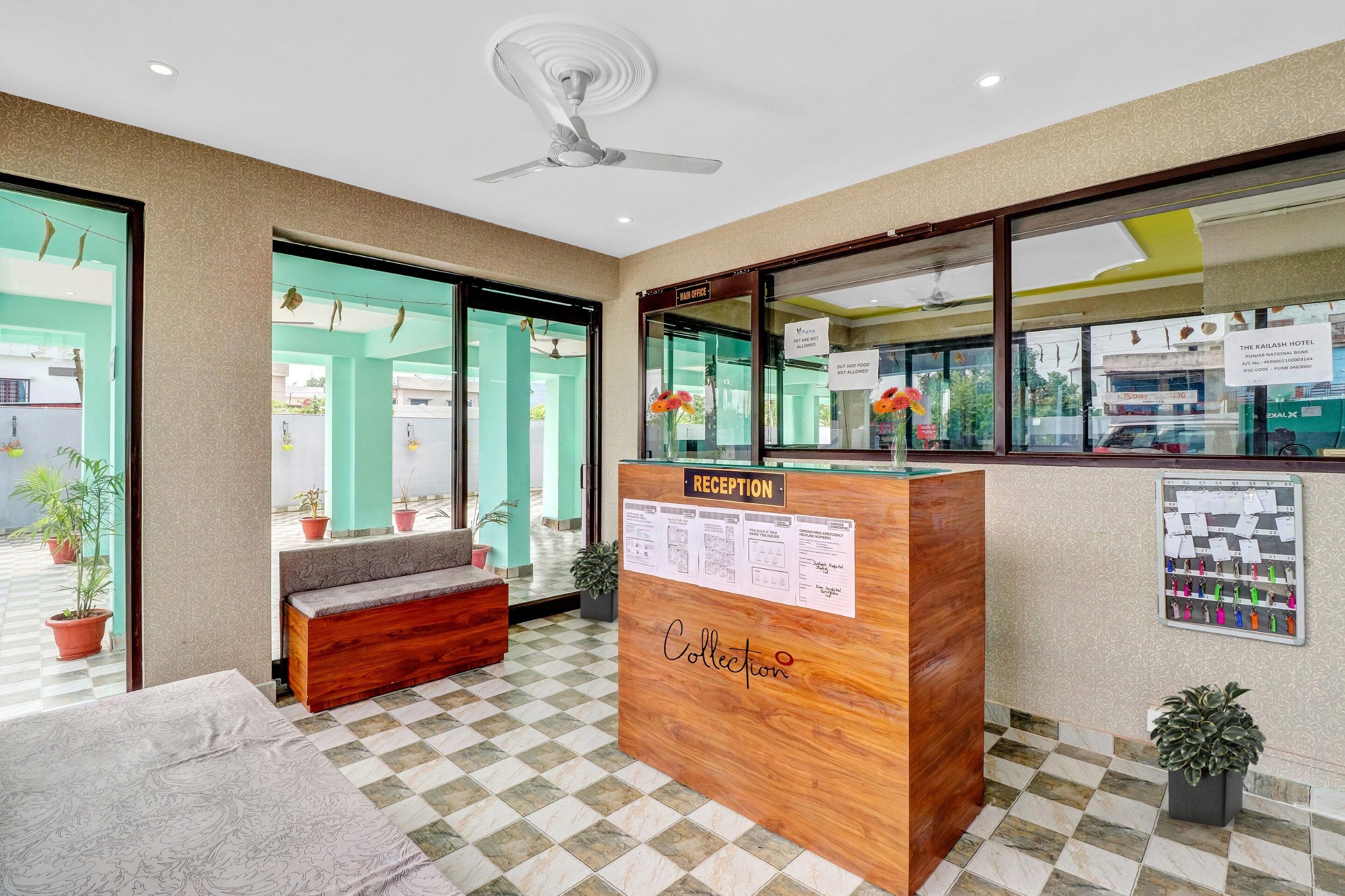 A reception desk with a 'Reception' sign, a 'Collection' sign, and a 'Main Office' sign.