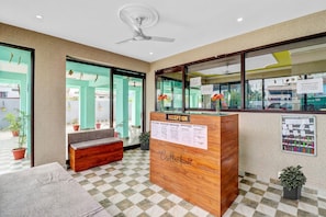 A reception desk with a 'Reception' sign, a 'Collection' sign, and a 'Main Office' sign.