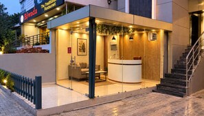 A modern hotel lobby with a reception desk, seating area, and a staircase. - Hotel O Dhara (Dehradun)