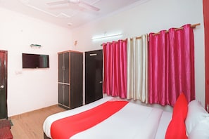A hotel room with a bed, a wardrobe, a television, and curtains. - Hotel O Mahalaxmi Palace (Dehradun)