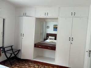 A bedroom with a bed, a dresser, and a mirror. - Brickwood apartments (Nairobi)