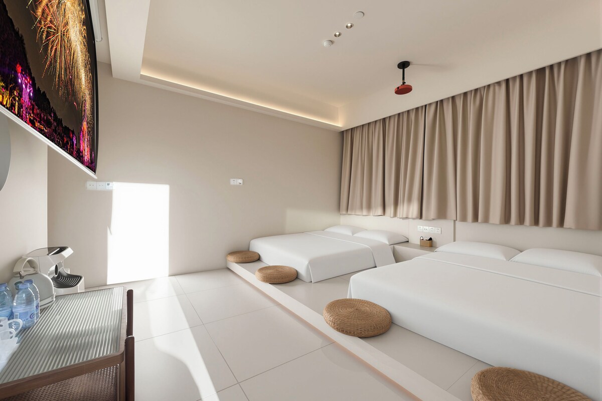 Una habitación de hotel moderna con una cama grande, un escritorio con silla y un televisor montado en la pared.
