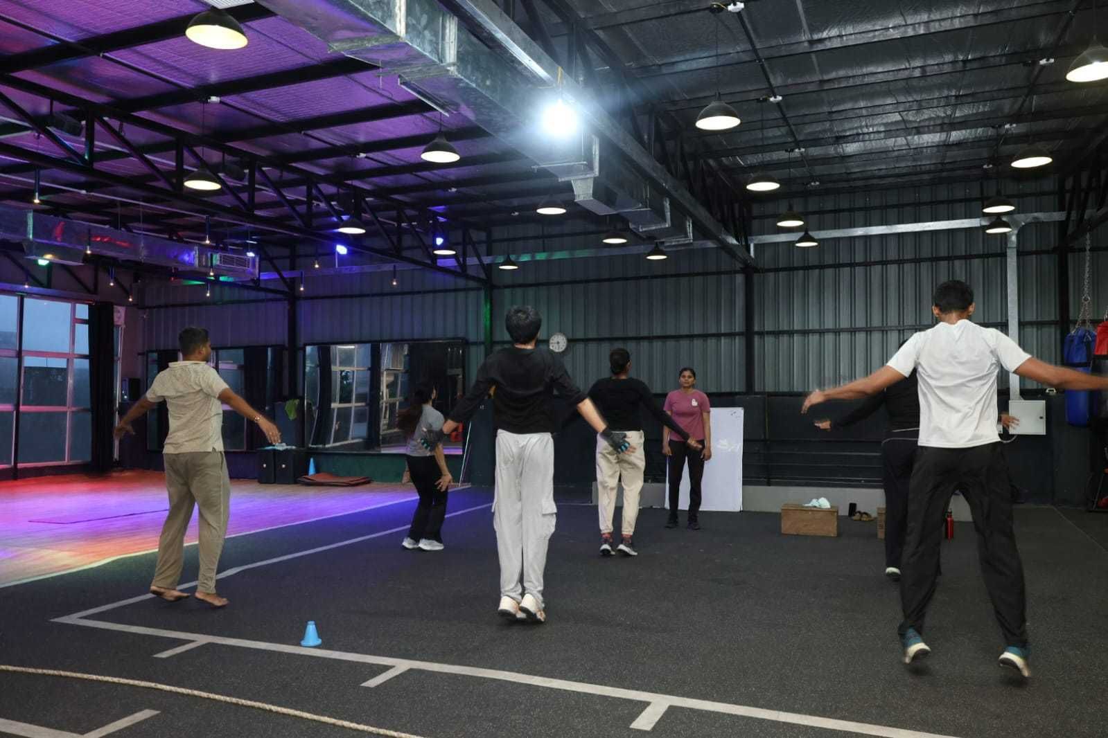 Un espacio interior con techos altos, iluminación de estilo industrial y una zona de escenario.