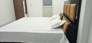A single bed with a headboard, a white bedspread, and two pillows. - Hotel O The Heaven Valley (Etawah)