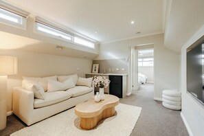 A modern living room with a sofa, a wooden coffee table, and a kitchen area in the background. - Waterfront Geelong - Bay View Bliss
Geelong CBD at your doorstep (Geelong)