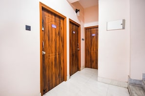A hallway with wooden doors, each labeled with a room number.