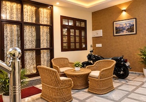 Quarto com móveis de vime, uma motocicleta e um quadro pendurado na parede.