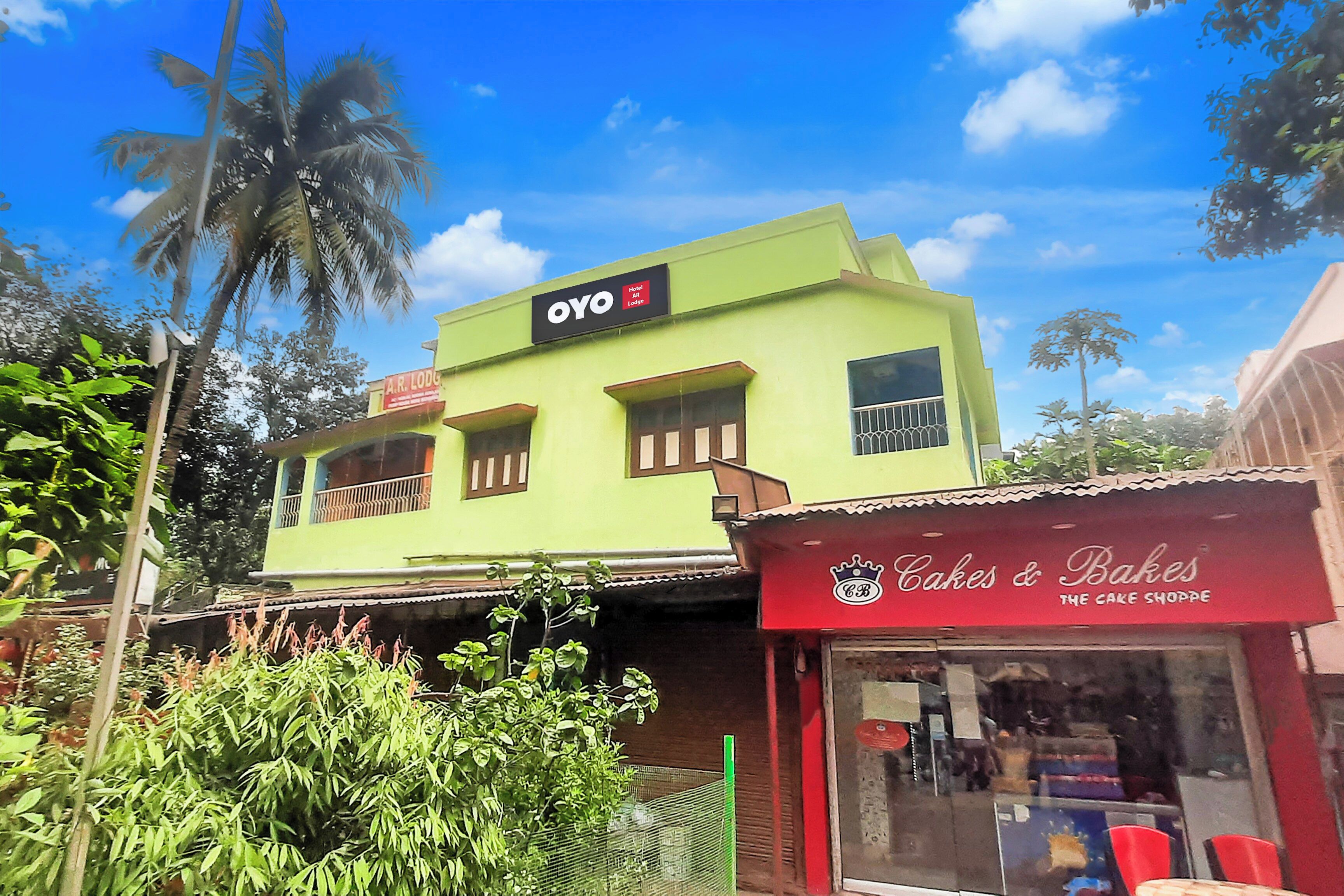 A two-story building with a sign for 'OYO Hotel AR Lodge' on the upper level.