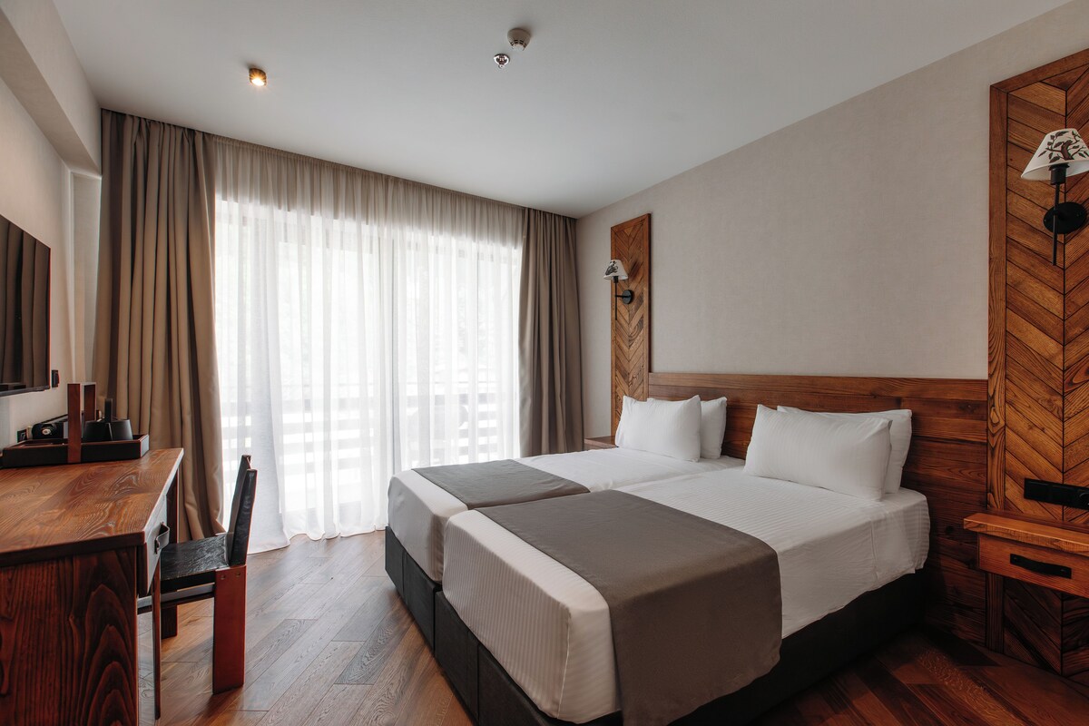 Ein Hotelzimmer mit einem großen Bett, einem Schreibtisch und einem Stuhl.