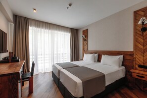 Ein Hotelzimmer mit einem großen Bett, einem Schreibtisch und einem Stuhl.