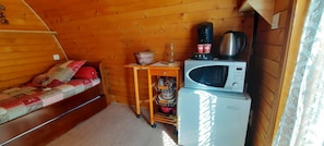 A compact room with a bed, a small table with a kettle, a microwave, and a refrigerator. - Cabin 'Gavarnie, Sanitaire Camping' with Mountain View, Private Terrace and Wi-Fi (Gavarnie-Gèdre)