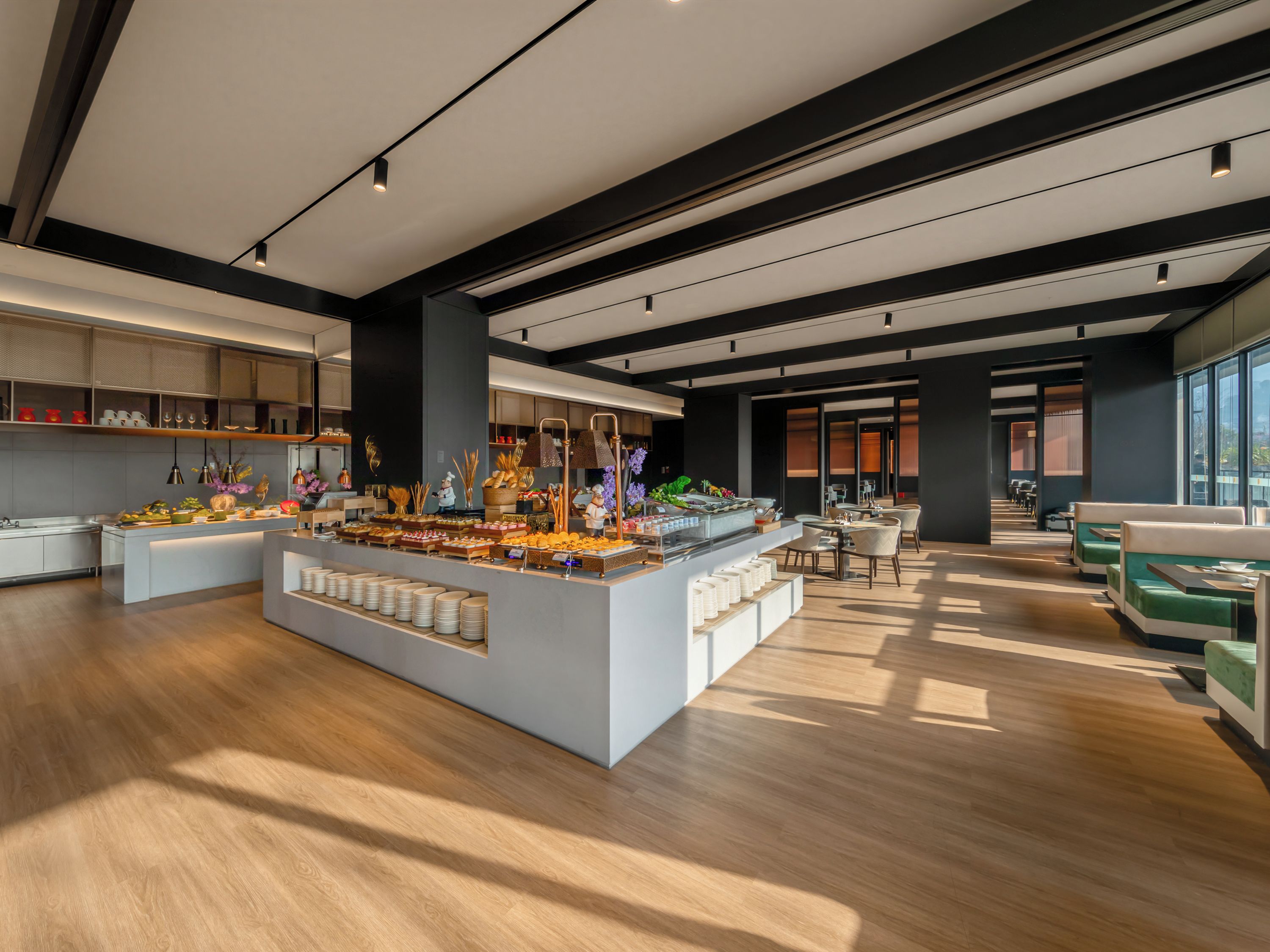 Un hall d’hôtel moderne doté d’un espace buffet central, de différents types de sièges et d’une disposition spacieuse.