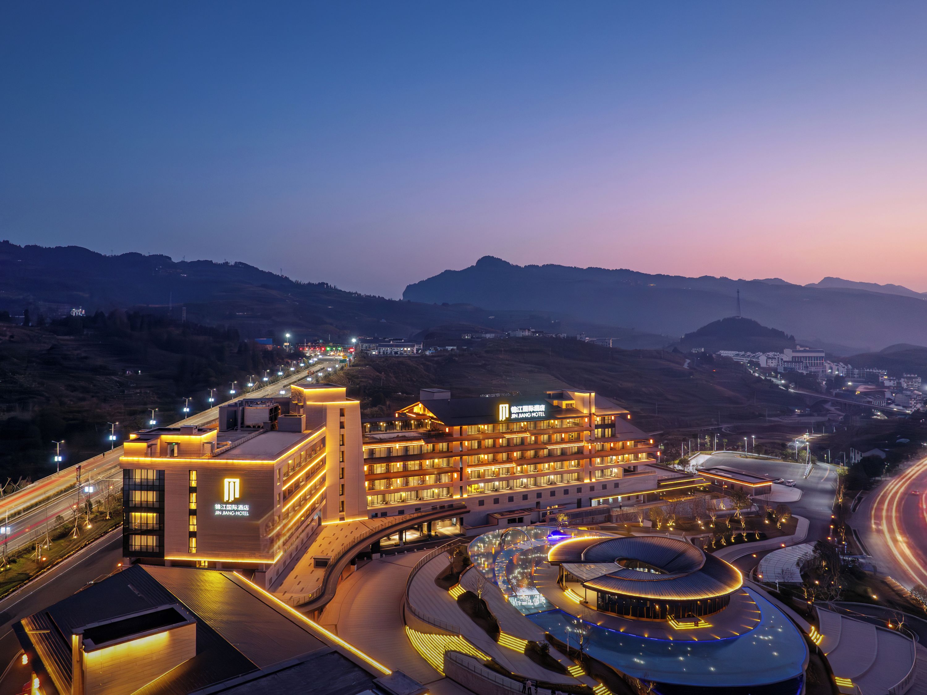 A modern hotel with multiple floors and a prominent circular structure in the center.