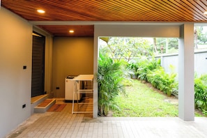A clean, modern entrance with a wooden ceiling, a small utility room, and a view of a lush garden area. - Hill Retreat 3BR Pool Villa near Nai Harn, Rawai (Tambon Rawai)