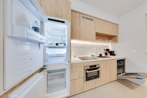 A modern kitchen with a built-in refrigerator, oven, and dishwasher. - Resort-Style Pool + Gym + Sauna | Walk to Brightline | Miami Oasis at The Crosby (Miami)