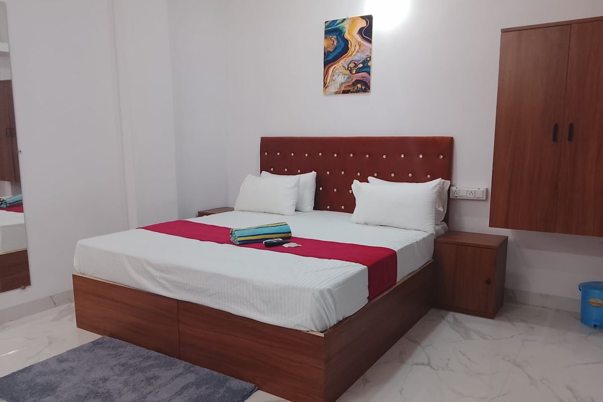 Une chambre d’hôtel avec un lit, une table de chevet, une armoire en bois, un sol en marbre et un tableau au mur.