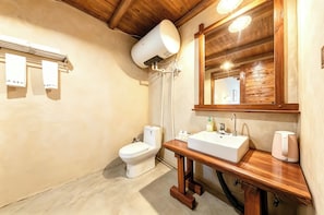 Een badkamer met toilet, wastafel en spiegel.