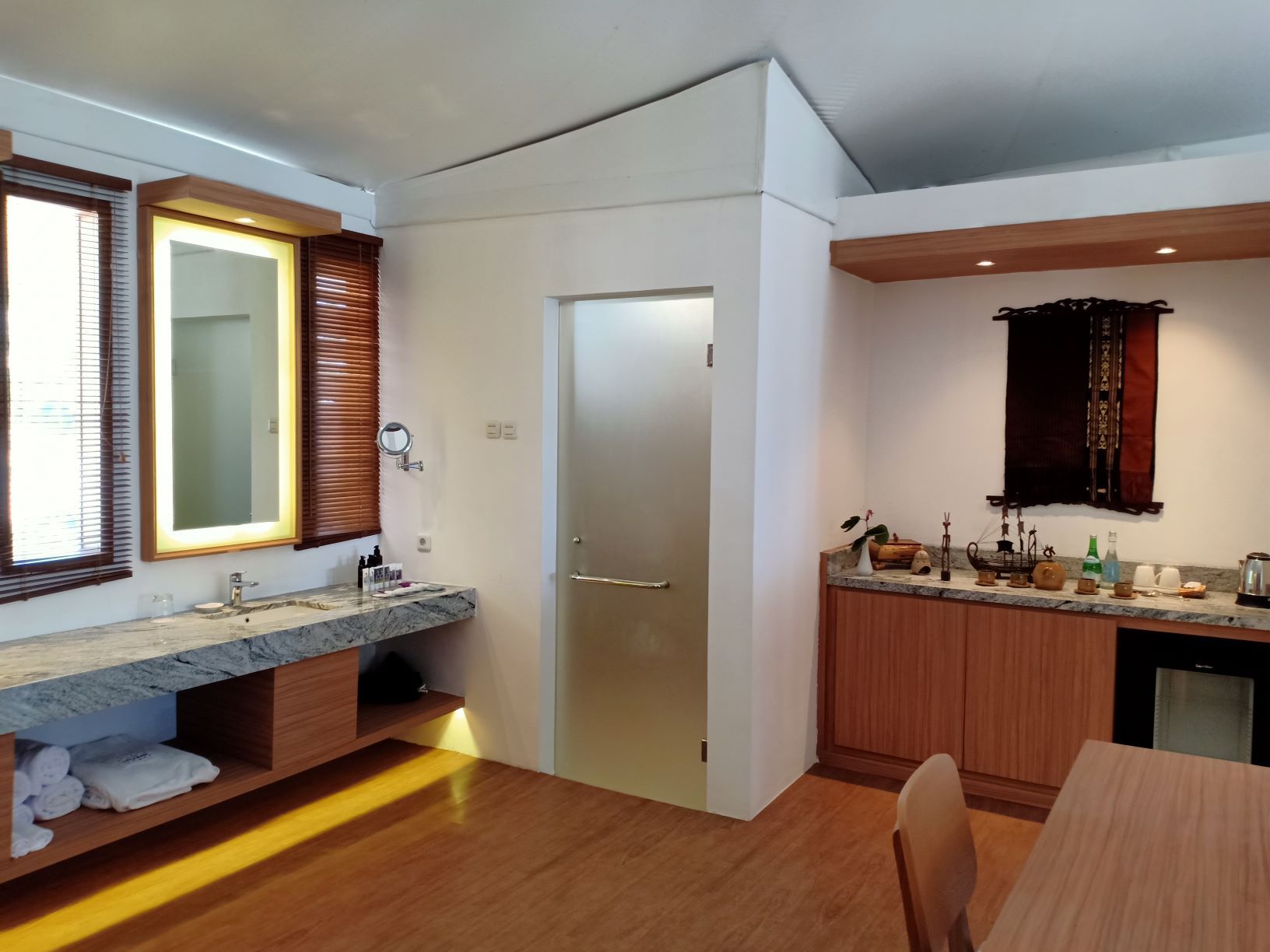 A modern kitchen with a marble countertop, wooden cabinets, and a built-in oven.