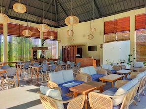 A spacious outdoor seating area with wicker furniture and a high ceiling. - Marahai Villa Morotai (Morotai Island)