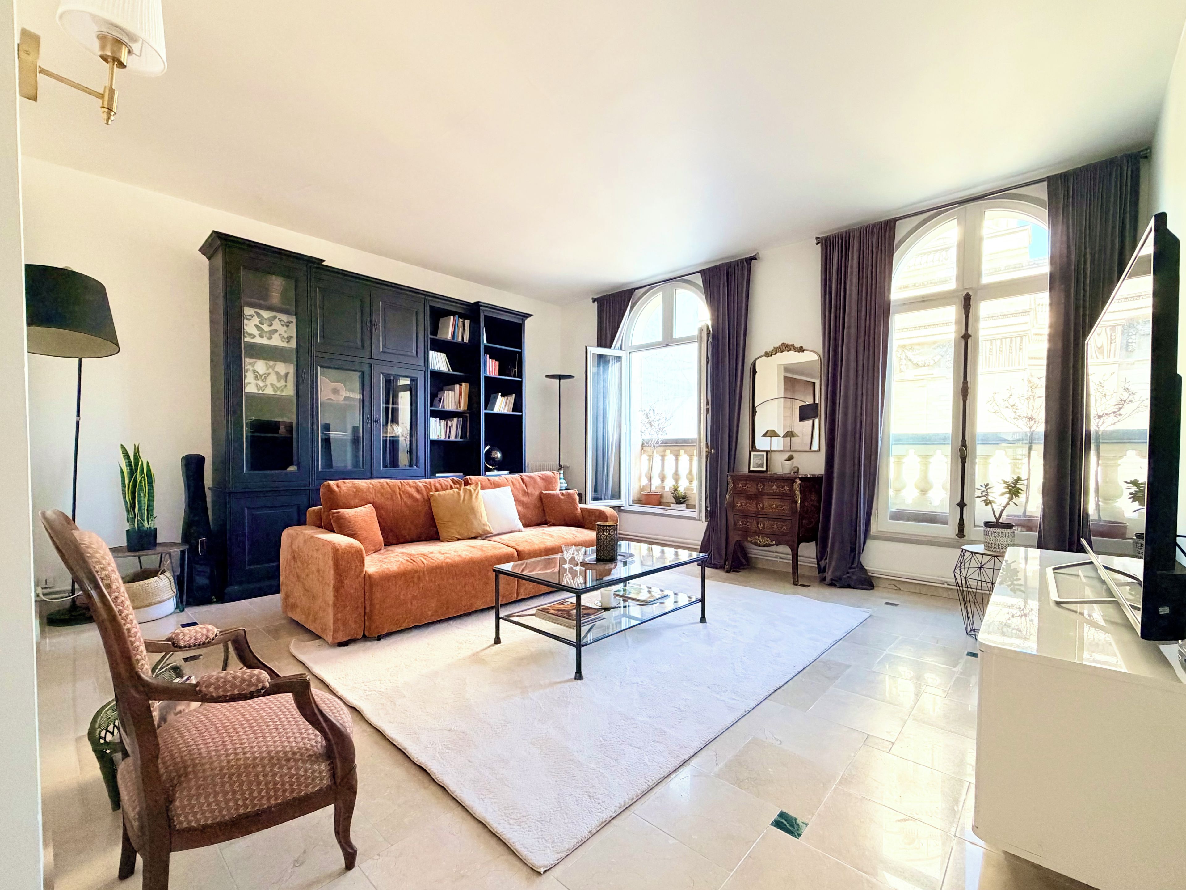 A living room with a sofa, armchair, coffee table, and a bookshelf.