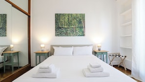 A hotel room with a large bed, two bedside tables with lamps, a mirror, and a painting on the wall. - Italianway Easy - Porta Nuova 52 D (Milan)