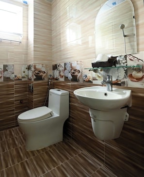 Een badkamer met toilet, wastafel en douche.