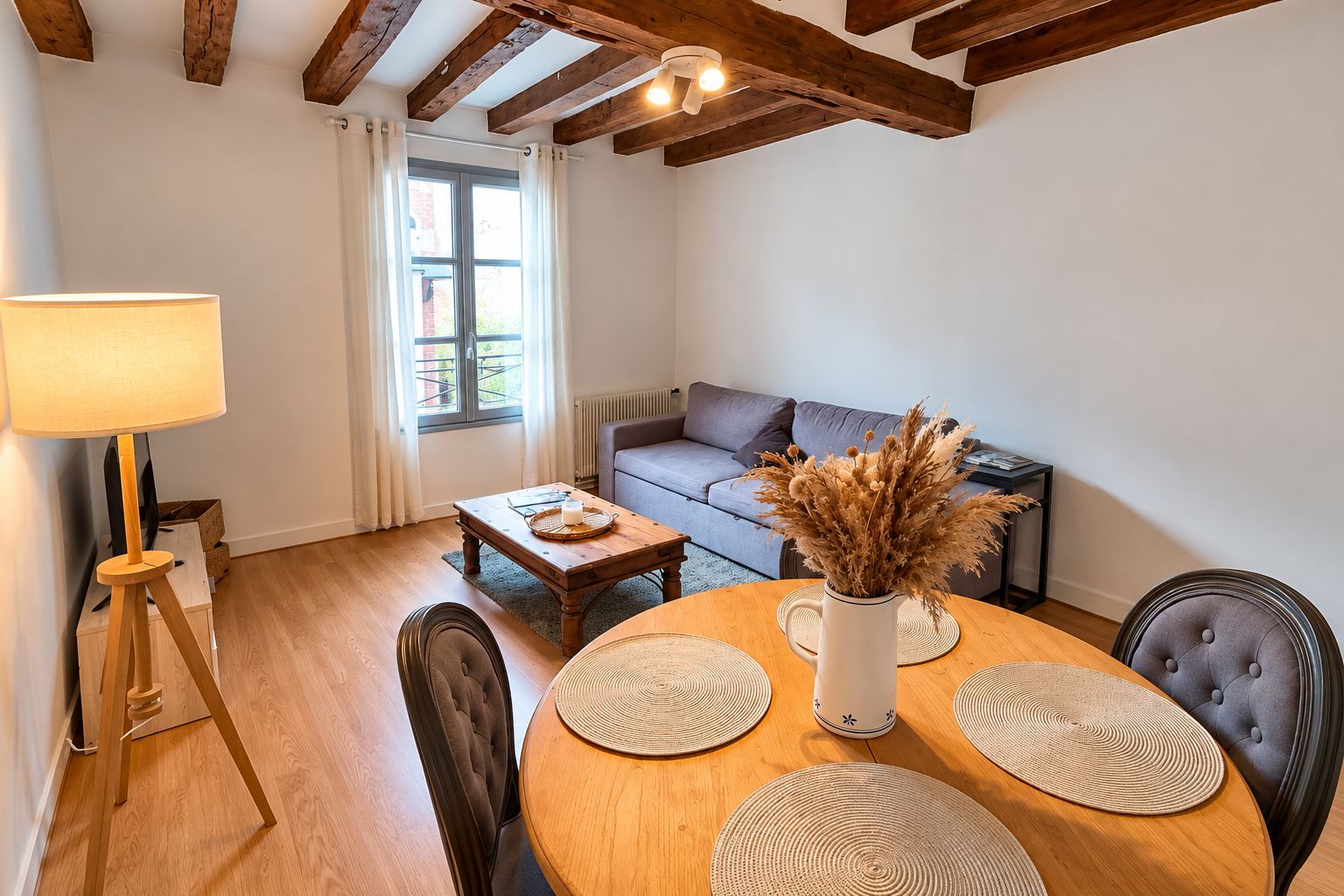 Un soggiorno accogliente con un tavolo da pranzo in legno, un divano e una lampada.