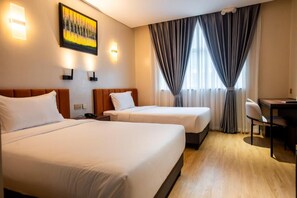 A hotel room with two beds, a desk, and a chair. - Hotel George (Cebu)