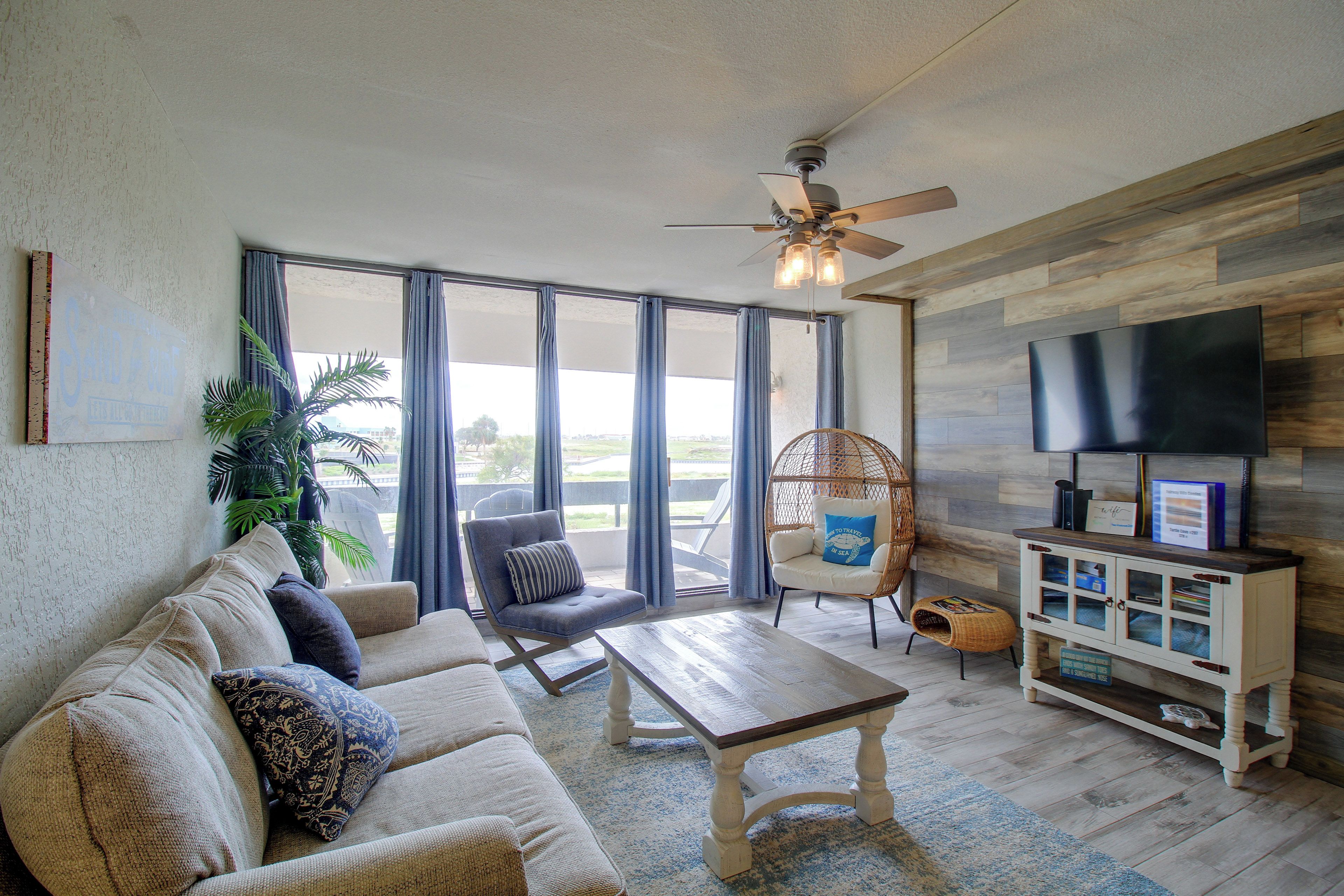 A living room with a sofa, a chair, a coffee table, a television, and a bookshelf.