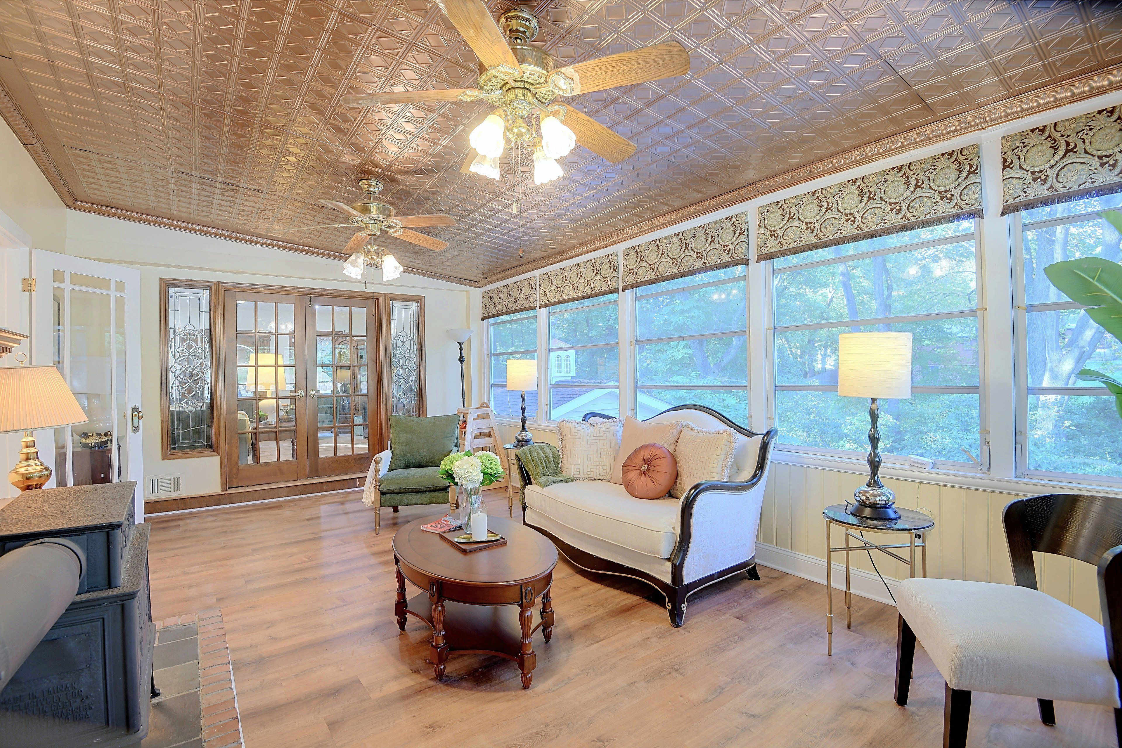 A spacious living room with a high ceiling, large windows, and a classic wooden coffee table.