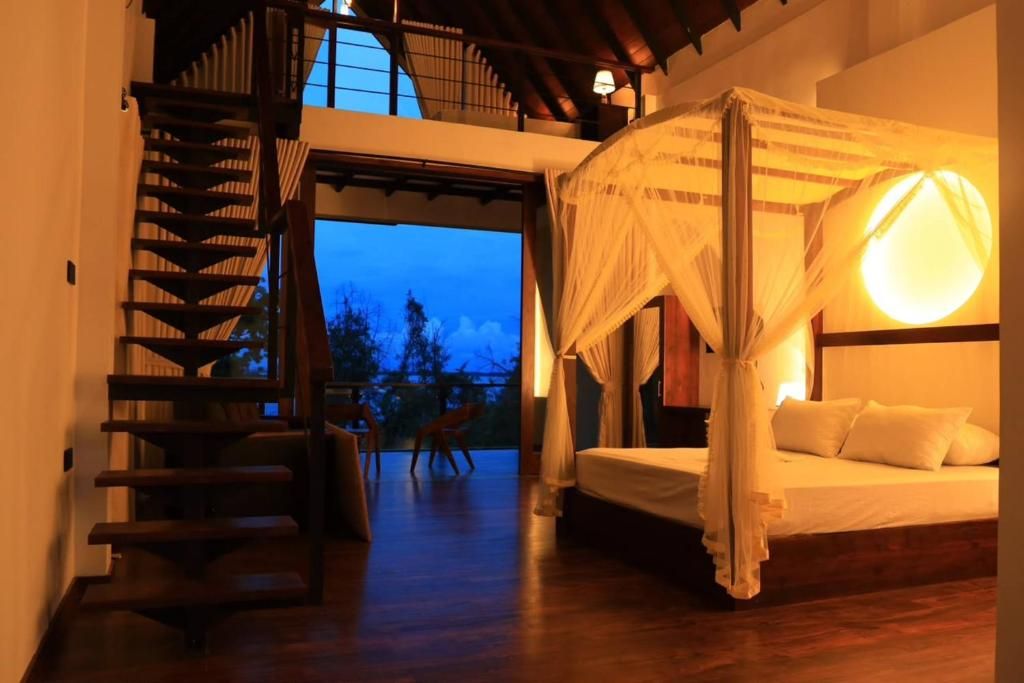 Ein Schlafzimmer mit Himmelbett, einer Treppe und Blick ins Freie.