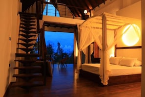 A bedroom with a four-poster bed, a staircase, and a view of the outdoors. - Safari Lake Resort Udawalawe (Udawalawe)