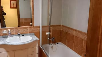Een badkamer met een bad, een wastafel en een douche.