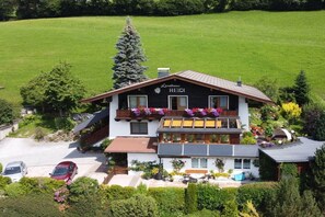 A two-story building with a sign reading 'Landhaus Heidi' and a balcony with flowers.