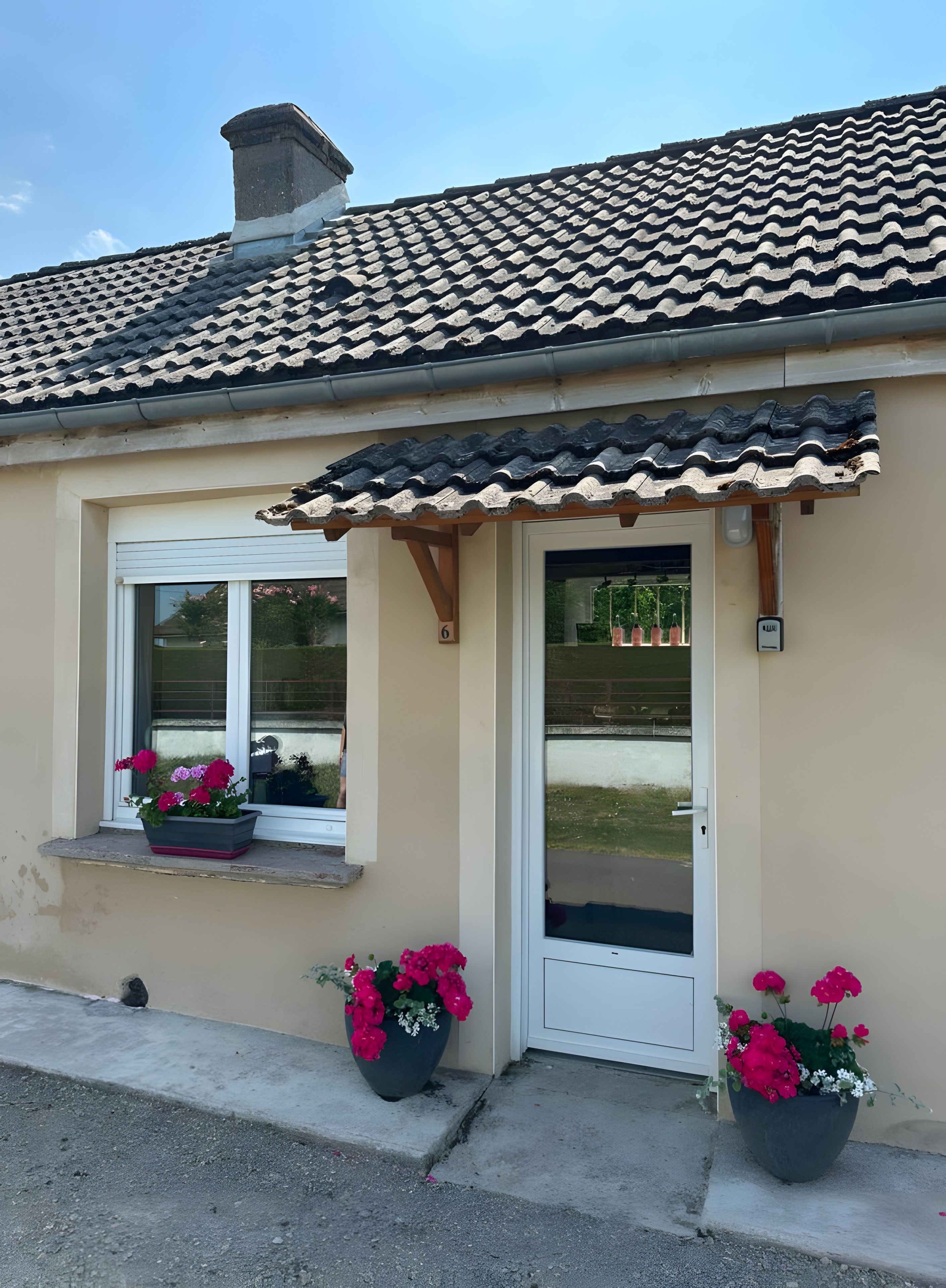 A building with a tiled roof, a white door, and windows with flower boxes.